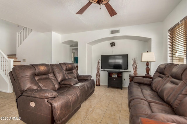 5220 W Desert Ln, Laveen, AZ 85339 - living room featuring arched walkways, a ceiling fan, and stairway