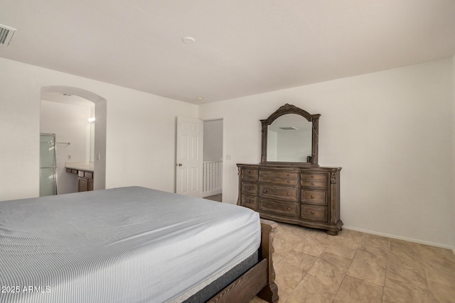 5220 W Desert Ln, Laveen, AZ 85339 - bedroom featuring arched walkways, baseboards, and connected bathroom