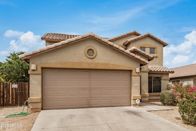 5220 W Desert Ln, Laveen, AZ 85339 - mediterranean / spanish-style house featuring an attached garage, driveway, a tiled roof, and stucco siding