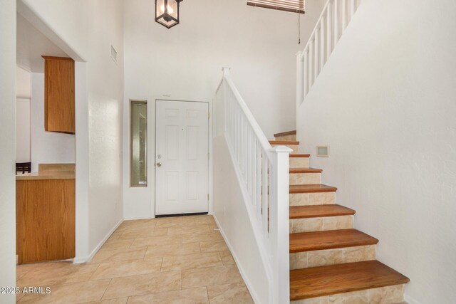 5220 W Desert Ln, Laveen, AZ 85339 - foyer featuring a high ceiling, stairway, baseboards, and light stone finish flooring