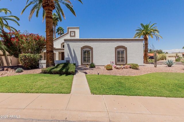 view of front of house featuring a front lawn and stucco siding