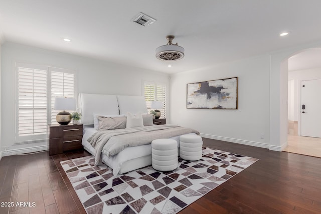 bedroom with visible vents, arched walkways, dark wood-style flooring, and recessed lighting