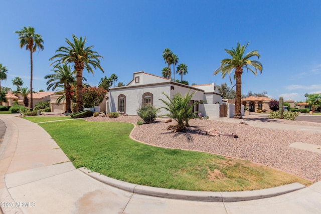 mediterranean / spanish-style home featuring a front lawn and stucco siding
