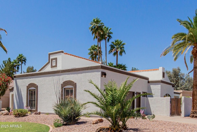 view of home's exterior with fence, a gate, and stucco siding