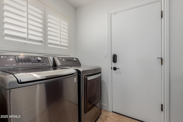 washroom with cabinet space, separate washer and dryer, and light tile patterned flooring