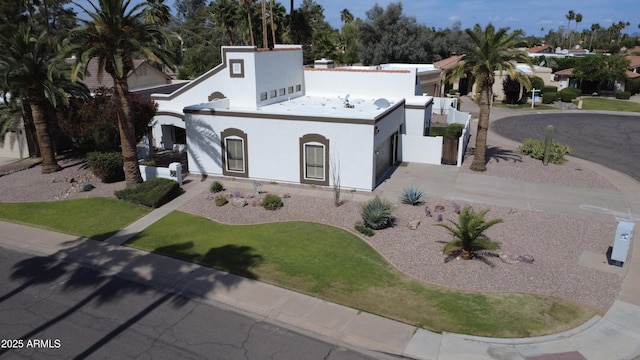 view of front of property with concrete driveway, an attached garage, and stucco siding
