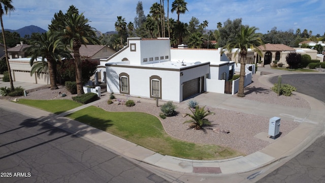 mediterranean / spanish-style house with a garage, stucco siding, and driveway