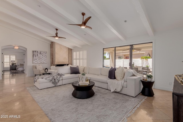 living area featuring light tile patterned floors, arched walkways, vaulted ceiling with beams, and a ceiling fan