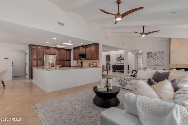 living area featuring ceiling fan, visible vents, arched walkways, light tile patterned floors, and recessed lighting