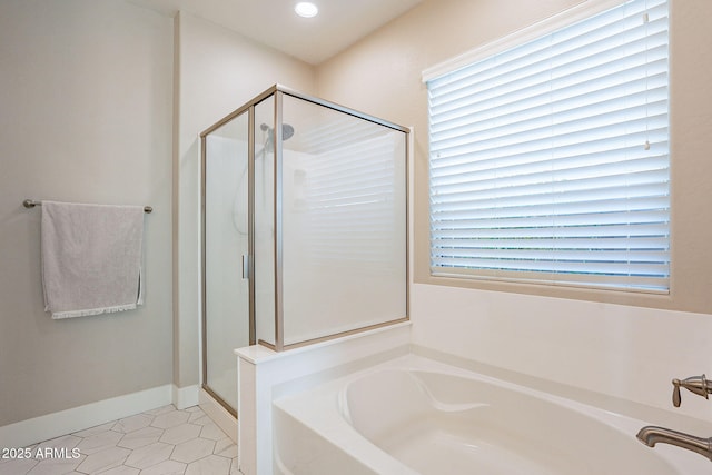 bathroom featuring tile patterned flooring, independent shower and bath, and a healthy amount of sunlight