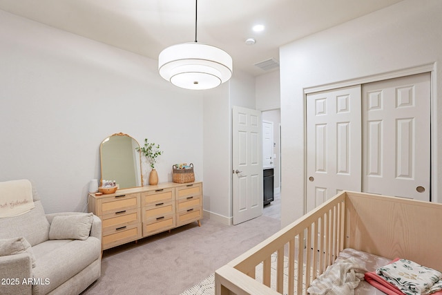 carpeted bedroom with a nursery area and a closet