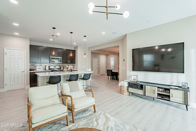 living room featuring a chandelier and light wood-type flooring