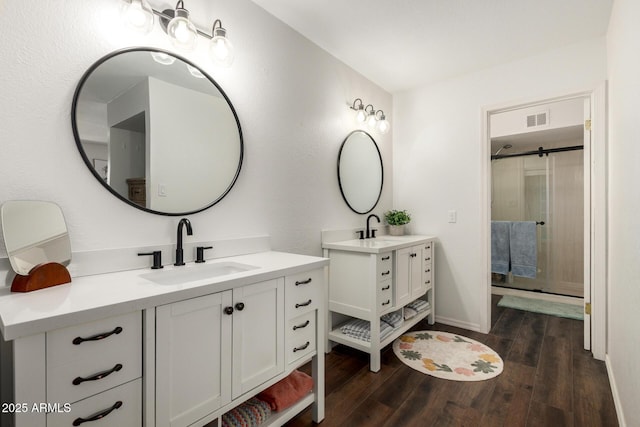 14235 N 26th Ln, Phoenix, AZ 85023 - bathroom featuring two vanities, wood finished floors, and a shower stall
