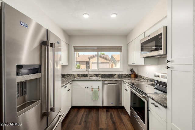 14235 N 26th Ln, Phoenix, AZ 85023 - kitchen with appliances with stainless steel finishes, dark wood finished floors, white cabinetry, dark stone countertops, and recessed lighting