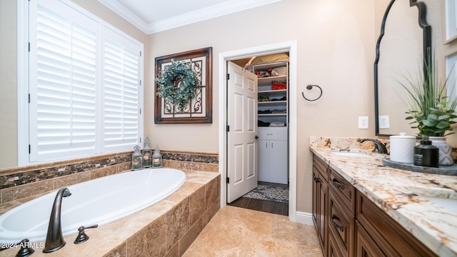 bathroom with vanity, a relaxing tiled tub, and ornamental molding