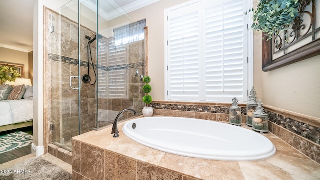 bathroom with ornamental molding and shower with separate bathtub