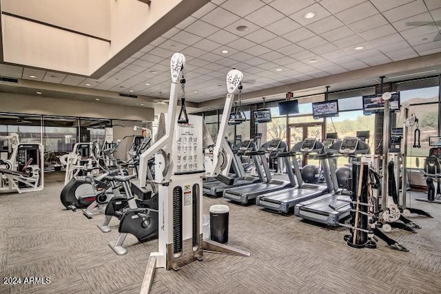 gym with a paneled ceiling and carpet floors