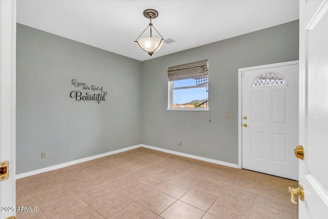 interior space featuring light tile patterned floors, visible vents, and baseboards