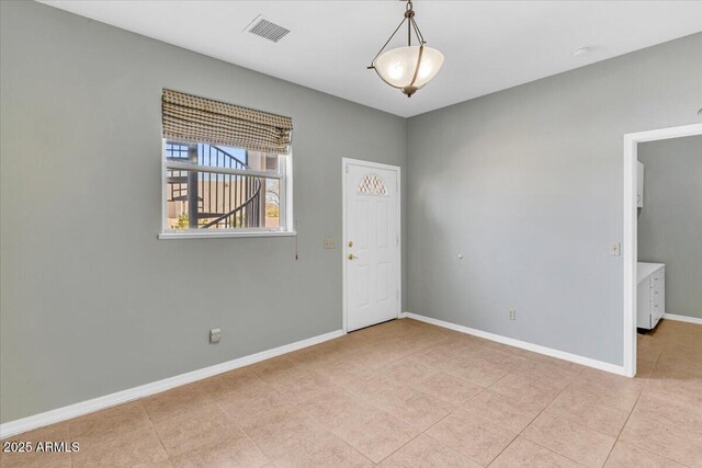 unfurnished room featuring baseboards, visible vents, and light tile patterned flooring