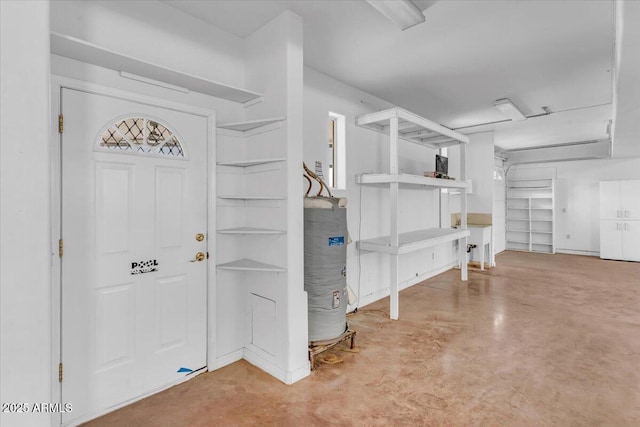 foyer entrance featuring concrete flooring and water heater