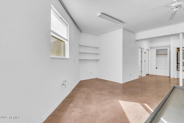 empty room featuring concrete floors, baseboards, and ceiling fan