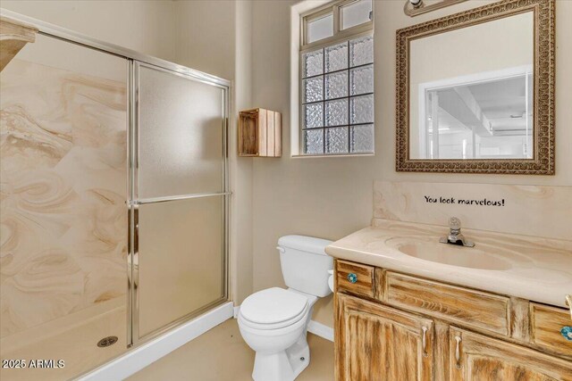 bathroom featuring vanity, toilet, and a shower stall