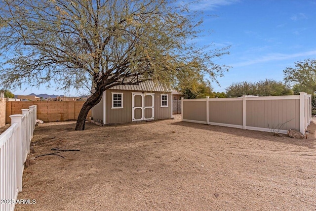 exterior space featuring a fenced backyard, a storage unit, and an outdoor structure