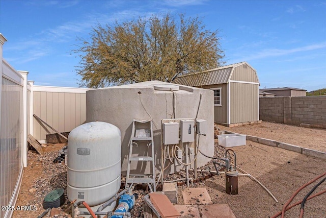 view of yard with a fenced backyard, a storage unit, and an outdoor structure