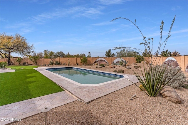 view of swimming pool featuring a fenced in pool, a fenced backyard, and a yard