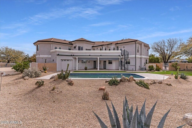 back of property featuring a fenced in pool, a patio, stucco siding, fence, and stairs