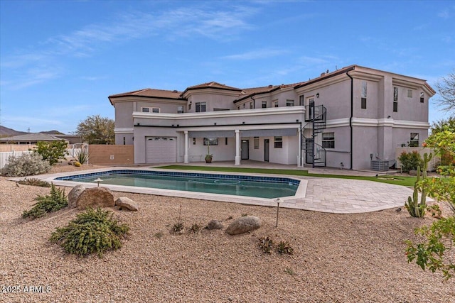 back of property featuring central AC unit, fence, stairway, and stucco siding