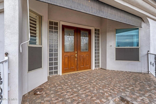 doorway to property featuring stucco siding