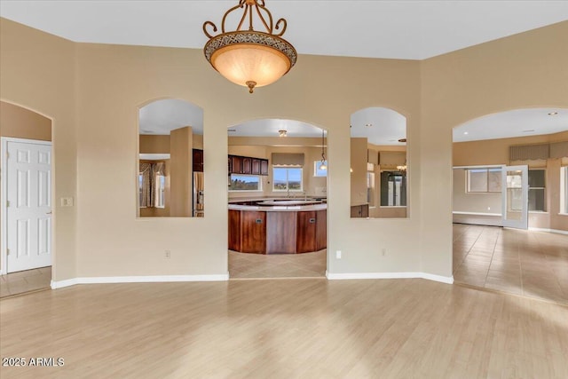 unfurnished living room with baseboards and light wood finished floors