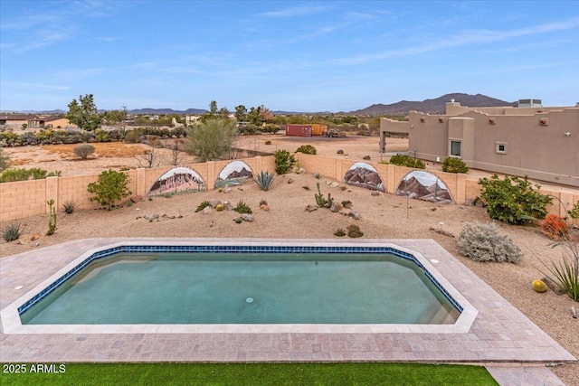 view of swimming pool with a fenced backyard, a mountain view, and a fenced in pool