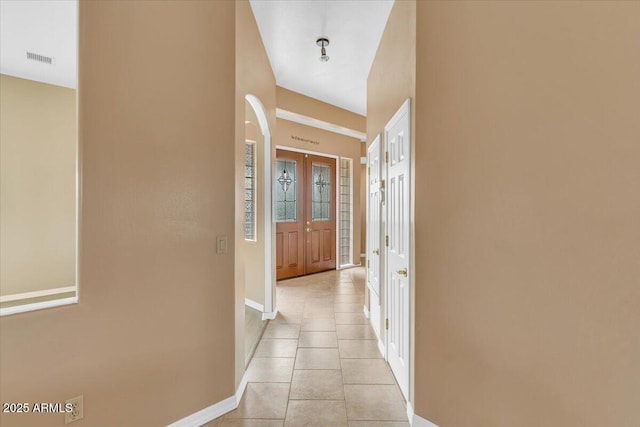 hallway with visible vents, baseboards, french doors, and light tile patterned flooring