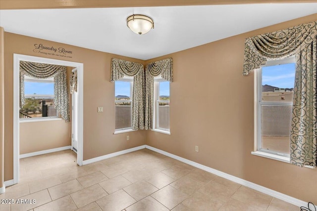 unfurnished dining area featuring light tile patterned floors and baseboards