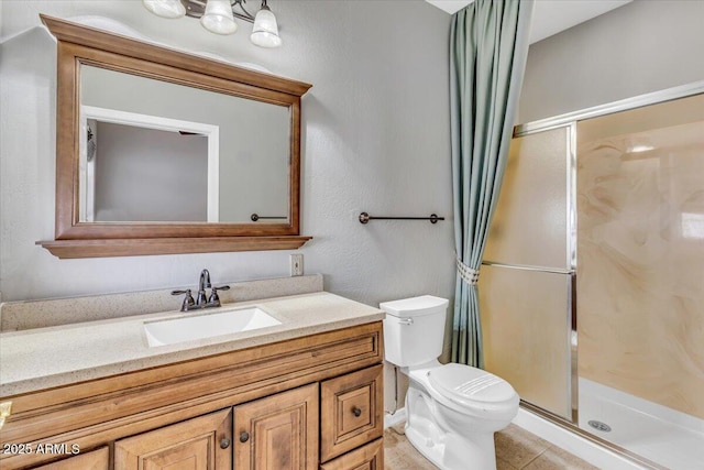 bathroom with a stall shower, tile patterned flooring, vanity, and toilet