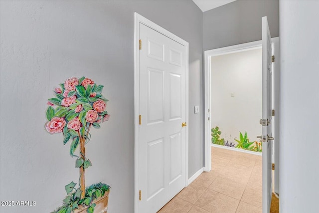 corridor with baseboards and light tile patterned floors