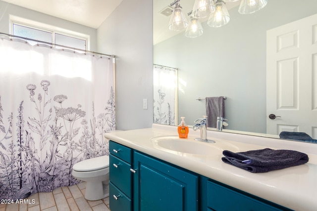 bathroom featuring vanity, toilet, lofted ceiling, and a notable chandelier