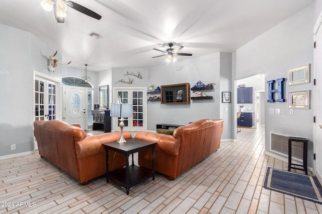 living room featuring french doors, light wood-type flooring, and ceiling fan