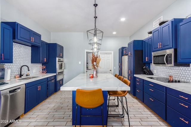 kitchen featuring a center island, sink, stainless steel appliances, blue cabinets, and a breakfast bar