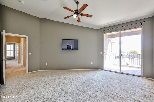 spare room featuring carpet flooring, baseboards, a ceiling fan, and vaulted ceiling
