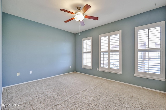 empty room with plenty of natural light, baseboards, carpet, and a ceiling fan