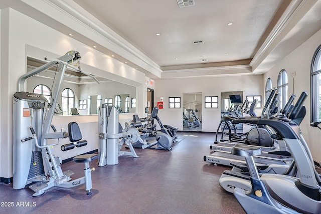workout area featuring visible vents, recessed lighting, baseboards, and a tray ceiling
