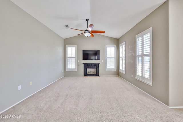 unfurnished living room with visible vents, a tiled fireplace, lofted ceiling, light carpet, and a ceiling fan
