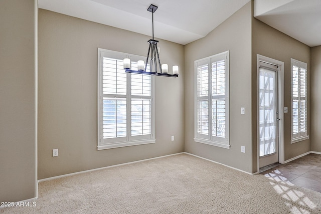 interior space featuring a notable chandelier, baseboards, and carpet