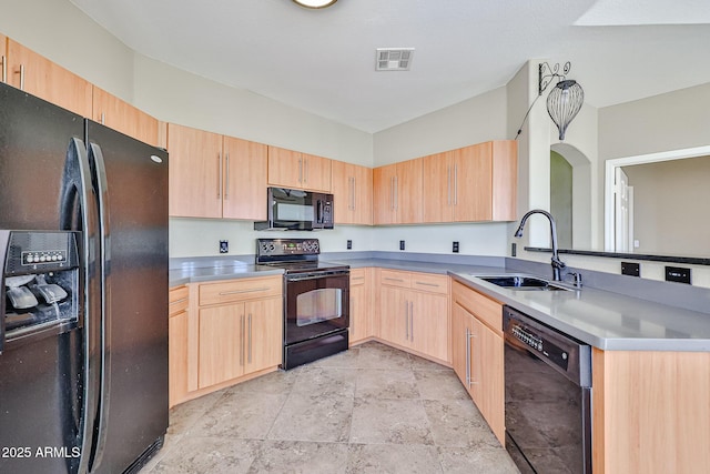 kitchen with visible vents, light brown cabinetry, a peninsula, black appliances, and a sink