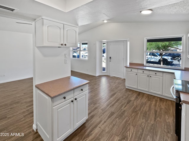 kitchen with white cabinets, vaulted ceiling, dark wood-style flooring, and a wealth of natural light