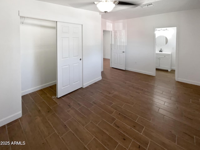 unfurnished bedroom with baseboards, visible vents, dark wood-style floors, and a closet