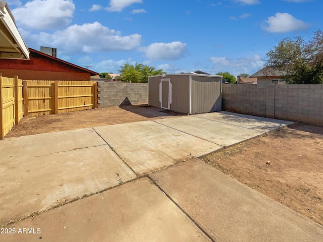 view of patio featuring a fenced backyard, a shed, and an outbuilding